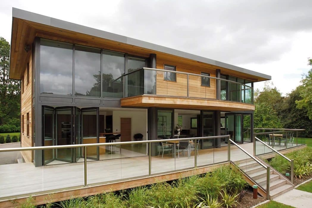 Moderne woning met houten gevel en glazen vouwwanden op de begane grond en de verdieping