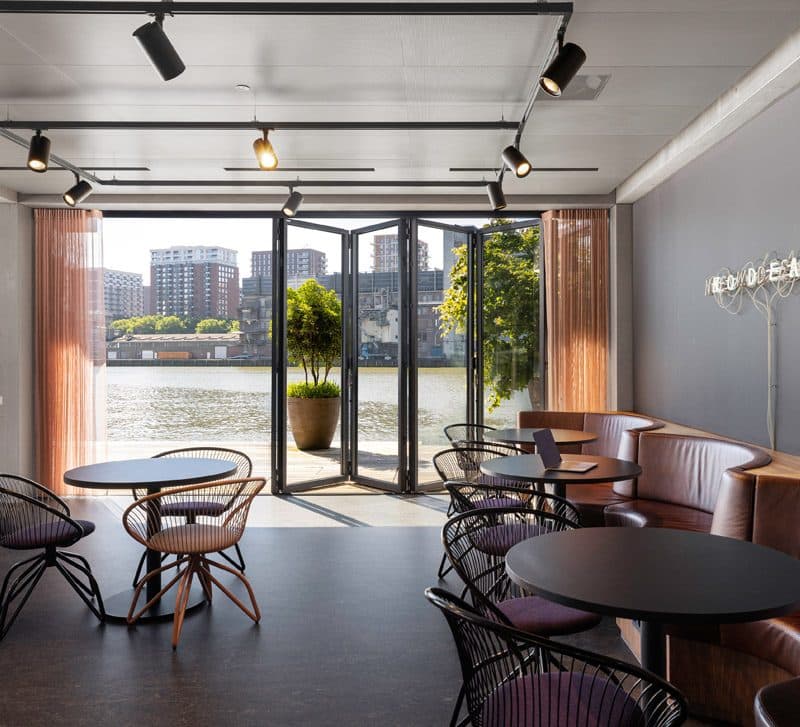 Restaurant met een geopende glazen pui naar een terras aan het water