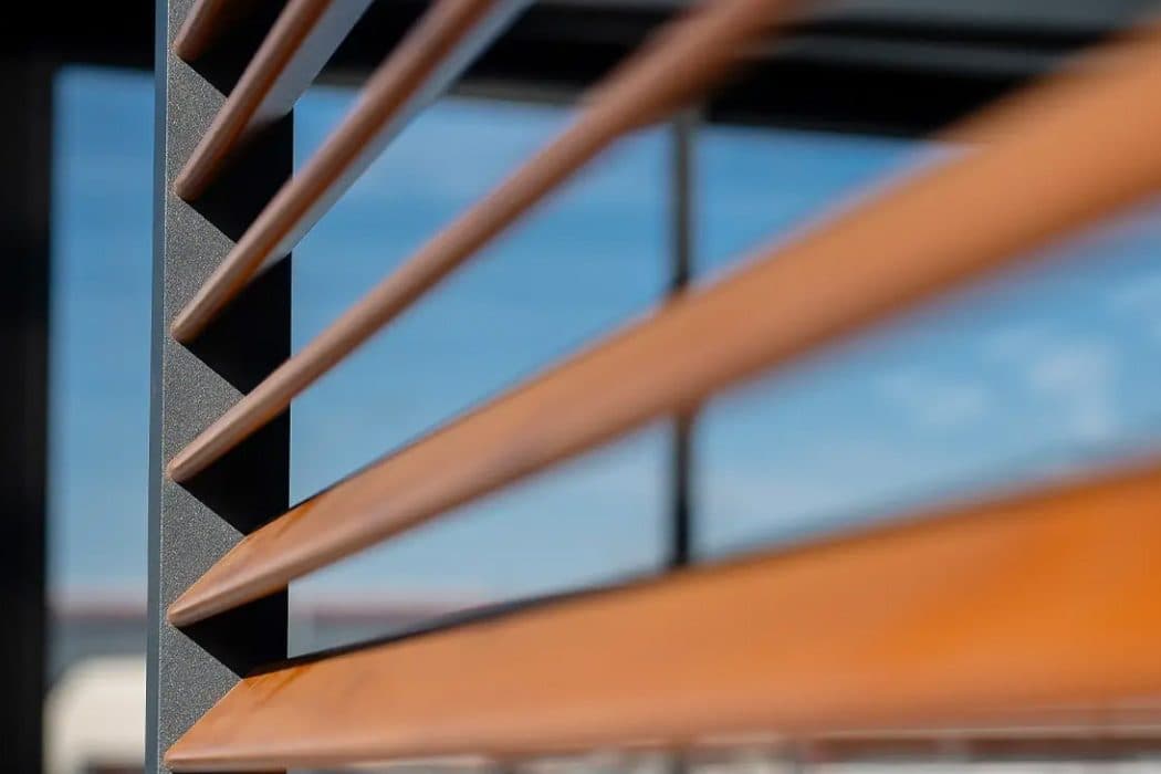 Close-up van aluminium lamellen in houtlook voor een raam