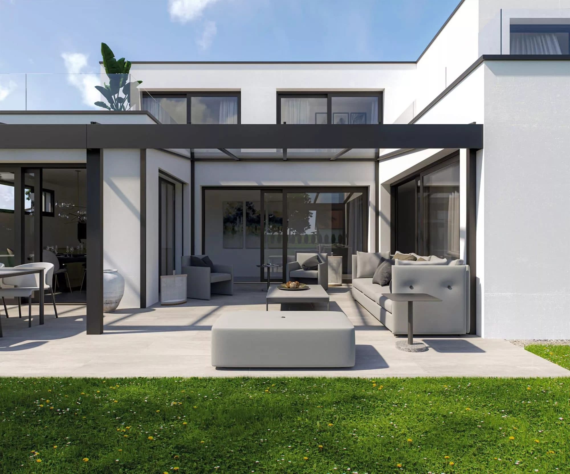 Strakke antraciet overkapping met vlakke goot tegen een witte woning, met een loungeset op een licht terras