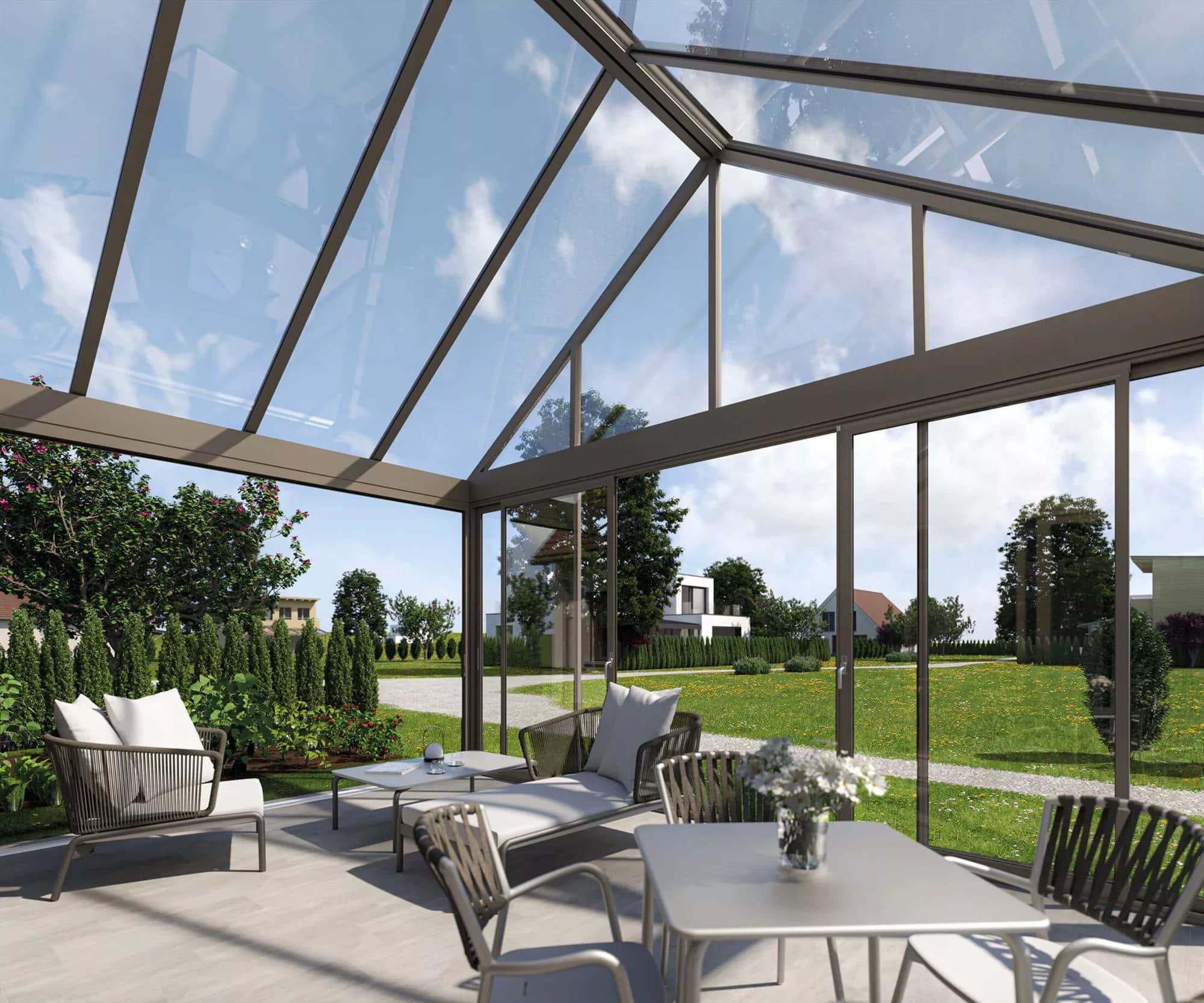 Zicht onder een glazen zadeldak met donkere spanten, op een terras met loungestoelen en een eettafel