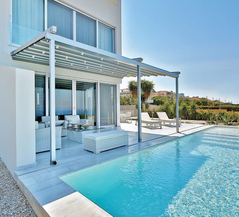 Wit vouwdak aan een moderne woning boven een terras met zwembad